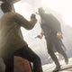 A cowboy wearing a black mask enters a bank and aims his gun at a person inside.